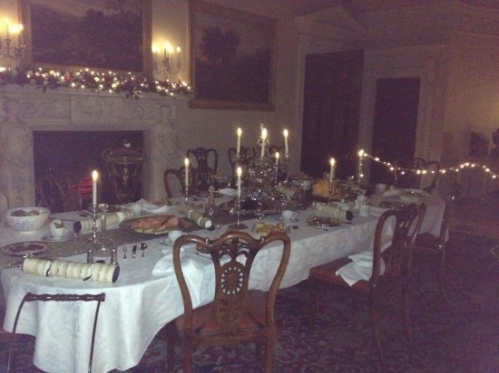 The Dining Room, set up for a holiday meal with candles and greenery.